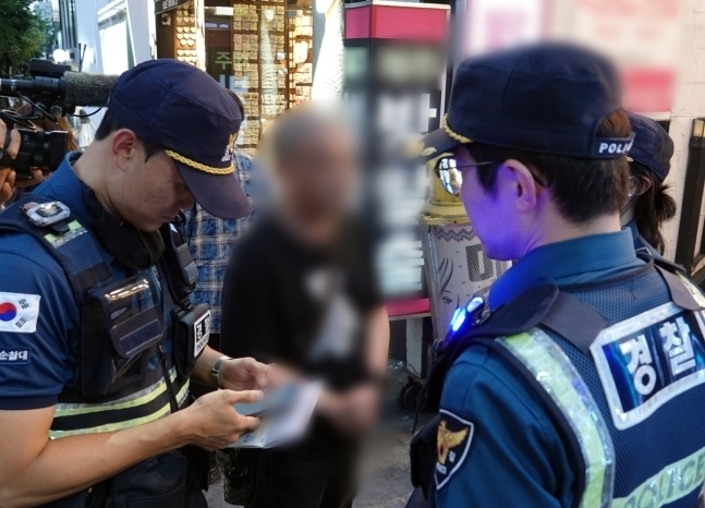 지난 25일 오후 제주시 제원사거리 인근 도로에서 무단횡단한 외국인 관광객에게 경찰이 범칙금을 부과하고 있다. 2024.6.27 연합뉴스
