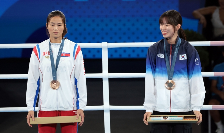 2024 파리 올림픽 복싱 여자 54㎏급에서 동메달을 획득한 우리나라 임애지(오른쪽)와 북한 방철미가 8일(현지시간) 프랑스 파리 롤랑가로스 경기장에서 열린 시상식에서 3위 단상에 나란히 서 있다. 2024.8.9 연합뉴스 2024 파리 올림픽 복싱 여자 54㎏급에서 동메달을 획득한 우리나라 임애지(오른쪽)와 북한 방철미가 8일(현지시간) 프랑스 파리 롤랑가로스 경기장에서 열린 시상식에서 3위 단상에 나란히 서 있다. 2024.8.9 연합뉴스