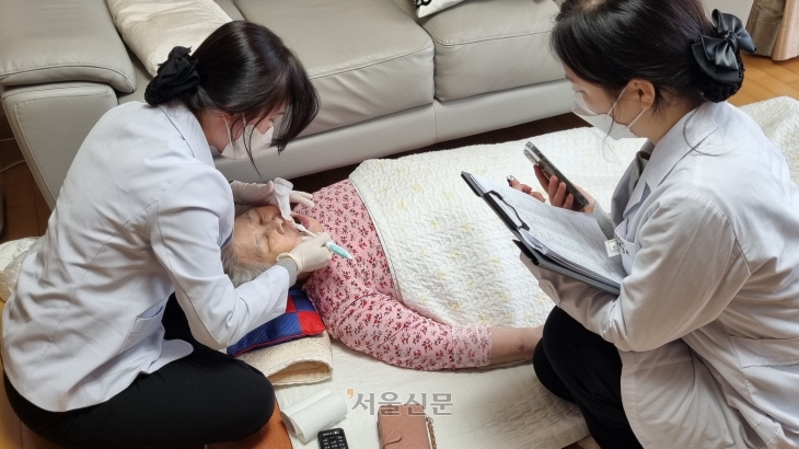 지난 25일 충남 천안의 한 아파트에서 치과위생사 이슬아씨가 현순자씨의 치아를 칫솔로 정성스레 닦아 내고 있다.