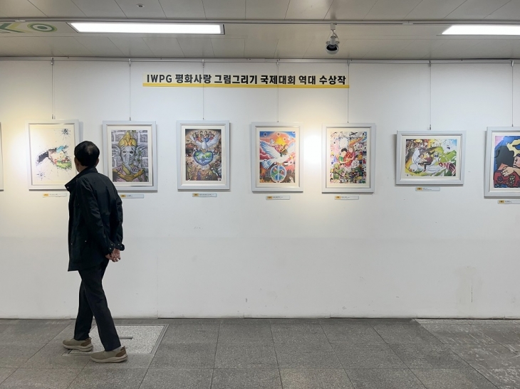 전시장을 방문한 시민들이 평화사랑 그림그리기 국제대회 수상작을 감상하고 있다