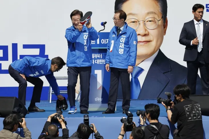 이재명 더불어민주당 대통령 후보가 12일 오전 서울 종로구 청계광장에서 열린 중앙선거대책위원회 출정식에서 구두를 벗고 운동화를 신고 있다. 2025.5.12 뉴스1 이재명 더불어민주당 대통령 후보가 12일 오전 서울 종로구 청계광장에서 열린 중앙선거대책위원회 출정식에서 구두를 벗고 운동화를 신고 있다. 2025.5.12 뉴스1