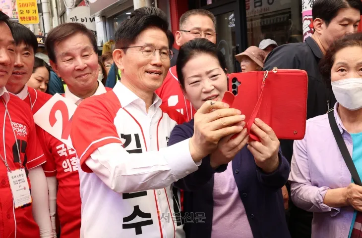 김문수 국민의힘 대선 후보가 13일 울산 남구의 한 시장에서 선거 유세 중 지지자와 함께 사진을 촬영하고 있다. 울산 안주영 전문기자 김문수 국민의힘 대선 후보가 13일 울산 남구의 한 시장에서 선거 유세 중 지지자와 함께 사진을 촬영하고 있다. 울산 안주영 전문기자