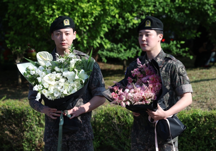 육군 현역 복무를 마친 그룹 방탄소년단(BTS)의 정국(왼쪽)과 지민이 11일 경기 연천군 연천공설운동장에서 전역 기념행사를 열고 있다. 연천 뉴스1