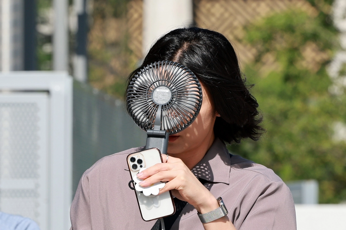 전국 대부분 지역에 폭염 특보가 발효된 지난 10일 서울 종로구에서 휴대용 선풍기를 든 시민이 이동하고 있다. 연합뉴스 전국 대부분 지역에 폭염 특보가 발효된 지난 10일 서울 종로구에서 휴대용 선풍기를 든 시민이 이동하고 있다. 연합뉴스